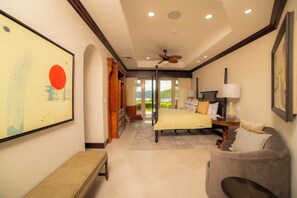 Quarto com cama, mesa de cabeceira, abajur e vista para o exterior.