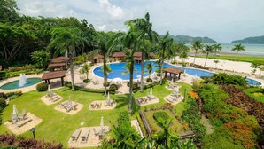 A resort with multiple swimming pools, palm trees, and a beach view. - Bella Vista 3A 3 Bdrs Ocean View in Los Suenos (Jacó)