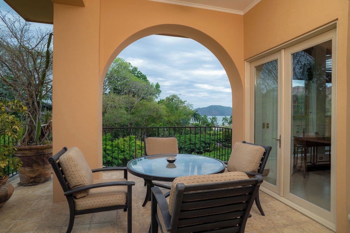 A covered patio with a glass door, a round table, and two chairs.