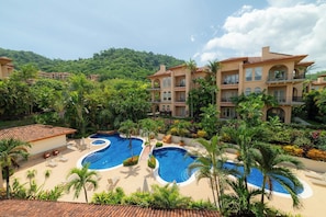 A resort with multiple swimming pools, lush greenery, and a mountainous backdrop. - Los Suenos Marina by Stay in Costa Rica (Jacó)