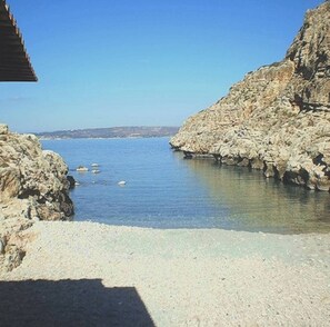A coastal scene with rocky terrain and clear blue water. - The most beautiful view of Crete at Villa Oniros (Chania kokkino chorio)