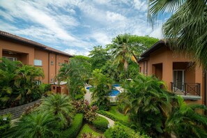 A resort with multiple buildings, a swimming pool, and lush greenery. - Veranda 3B 2 bdr Garden View in Los Suenos (Jacó)