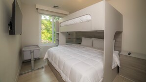 A bunk bed with a white duvet, a bedside table, a small window, and a wall-mounted TV. - Vista Los Suenos by Stay in Costa Rica (Jacó)