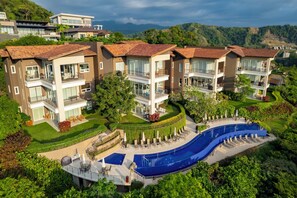 A modern residential complex with multiple two-story buildings, a central swimming pool, and well-maintained gardens. - Vista Los Suenos by Stay in Costa Rica (Jacó)