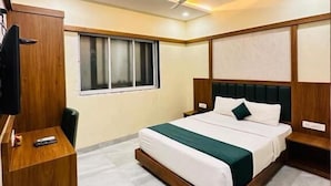 A modern hotel room with a large bed, a desk, a television, and a ceiling fan. - Hotel Downtown-Near US Embassy (Mumbai)
