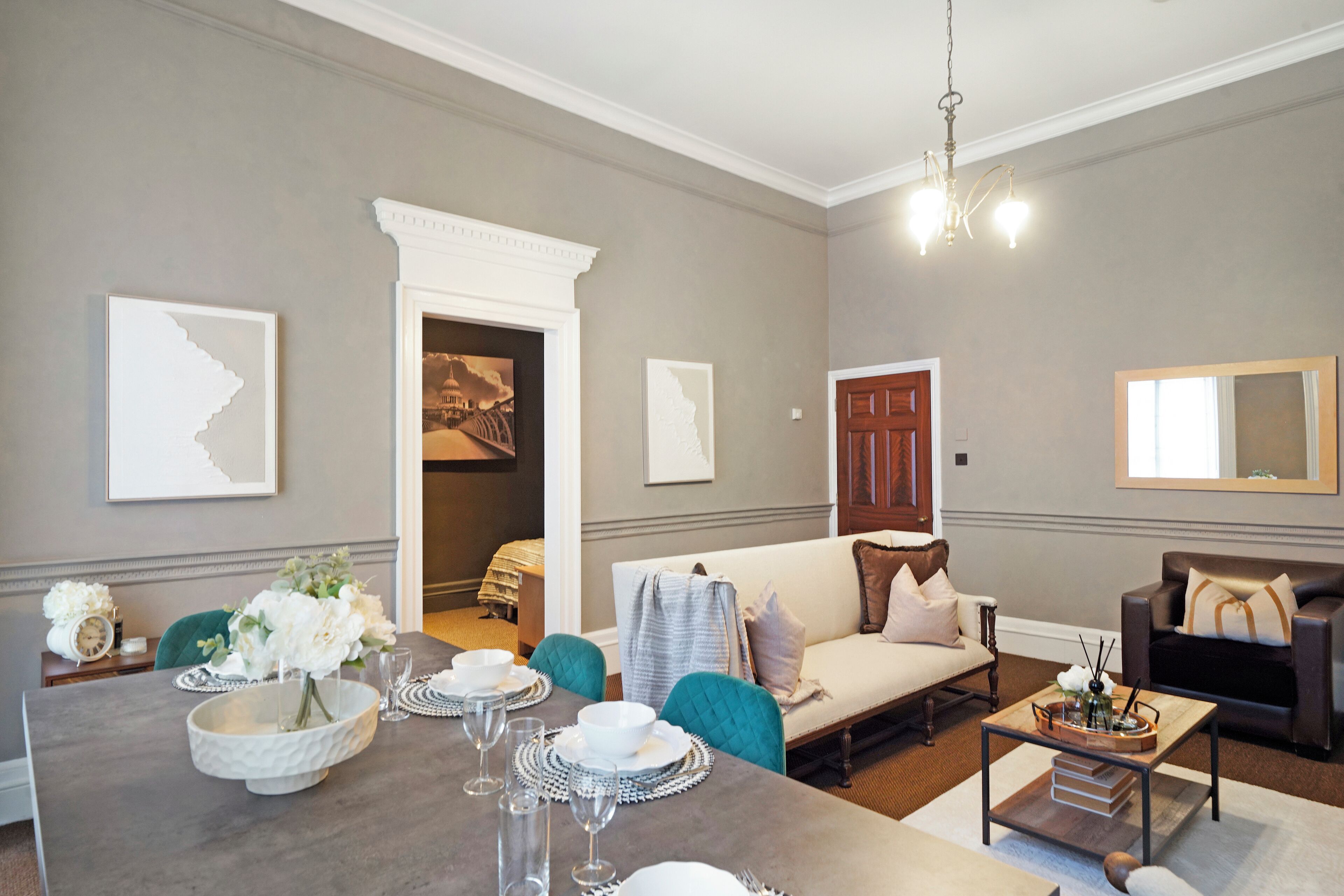 Un salon moderne avec un coin repas, des murs gris et des meubles contemporains.