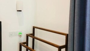 Una habitación con estructura de madera, pared blanca y un interruptor de luz verde.