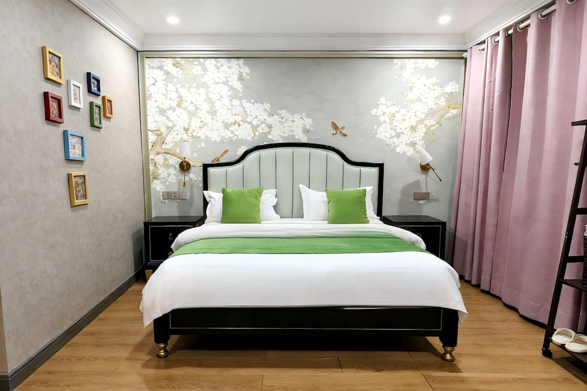 Ein ordentlich eingerichtetes Schlafzimmer mit einem Bett, Nachttischen und einem Wandregal.