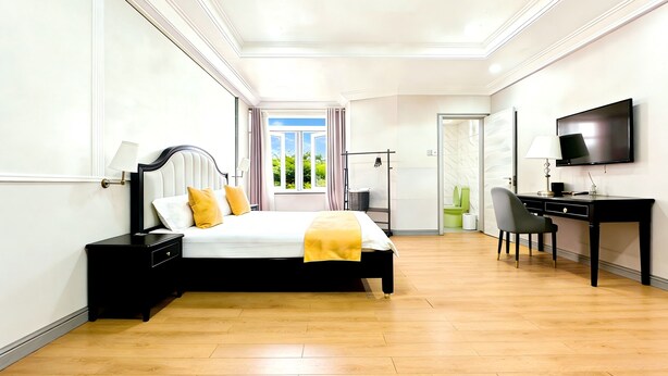 A modern hotel room with a large bed, a desk, a television, and a bathroom visible through an open door. - JUN YUE GRA Lagos hotel (Lagos)