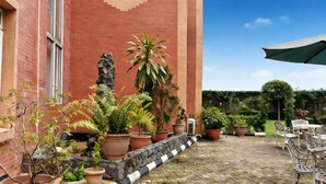 A courtyard with potted plants, a stone wall, and outdoor furniture. - JUN YUE GRA Lagos hotel (Lagos)