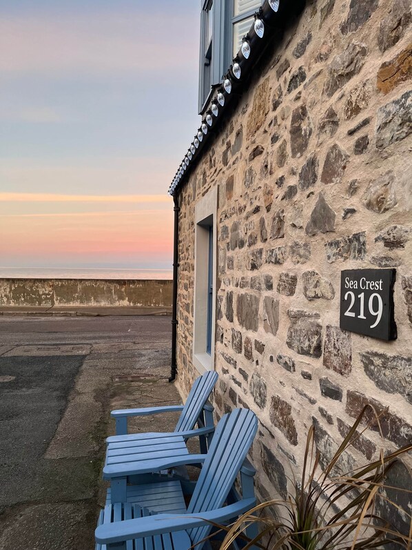 A stone building with a sign reading "Sea Crest 219" and a view of the sea.