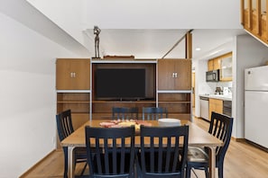 A compact kitchen with wooden cabinets, a microwave, and a refrigerator. - Ski-In/Ski-Out Condo • Pool, Hot Tub Access • Steps to KT-22 | The Traverse (Olympic Valley)