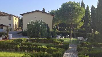 A garden with a gravel path, neatly trimmed hedges, and outdoor seating.