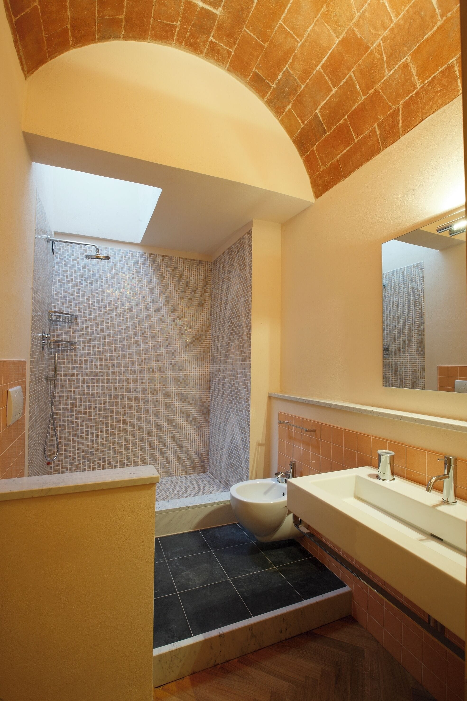Een badkamer met een douche, een wastafel en een toilet met bidetfunctie.
