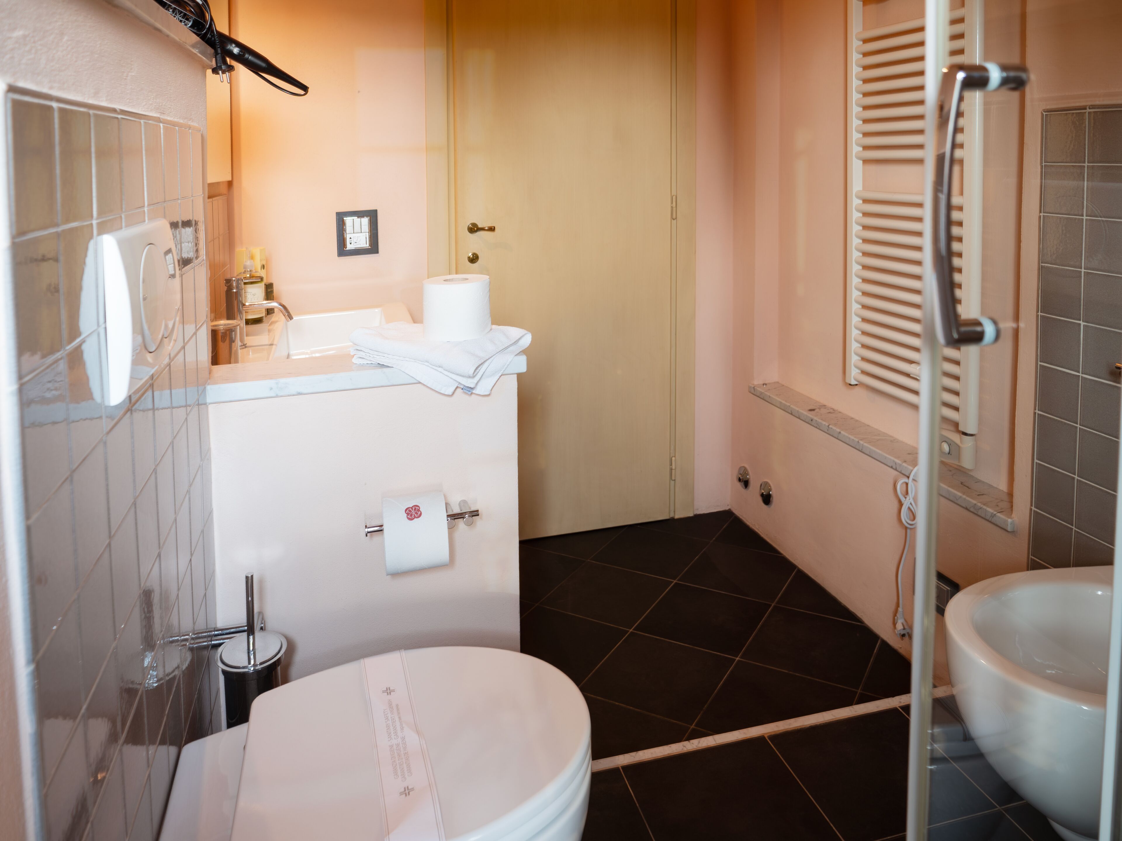Une salle de bain comprenant des toilettes, un bidet et un espace douche.