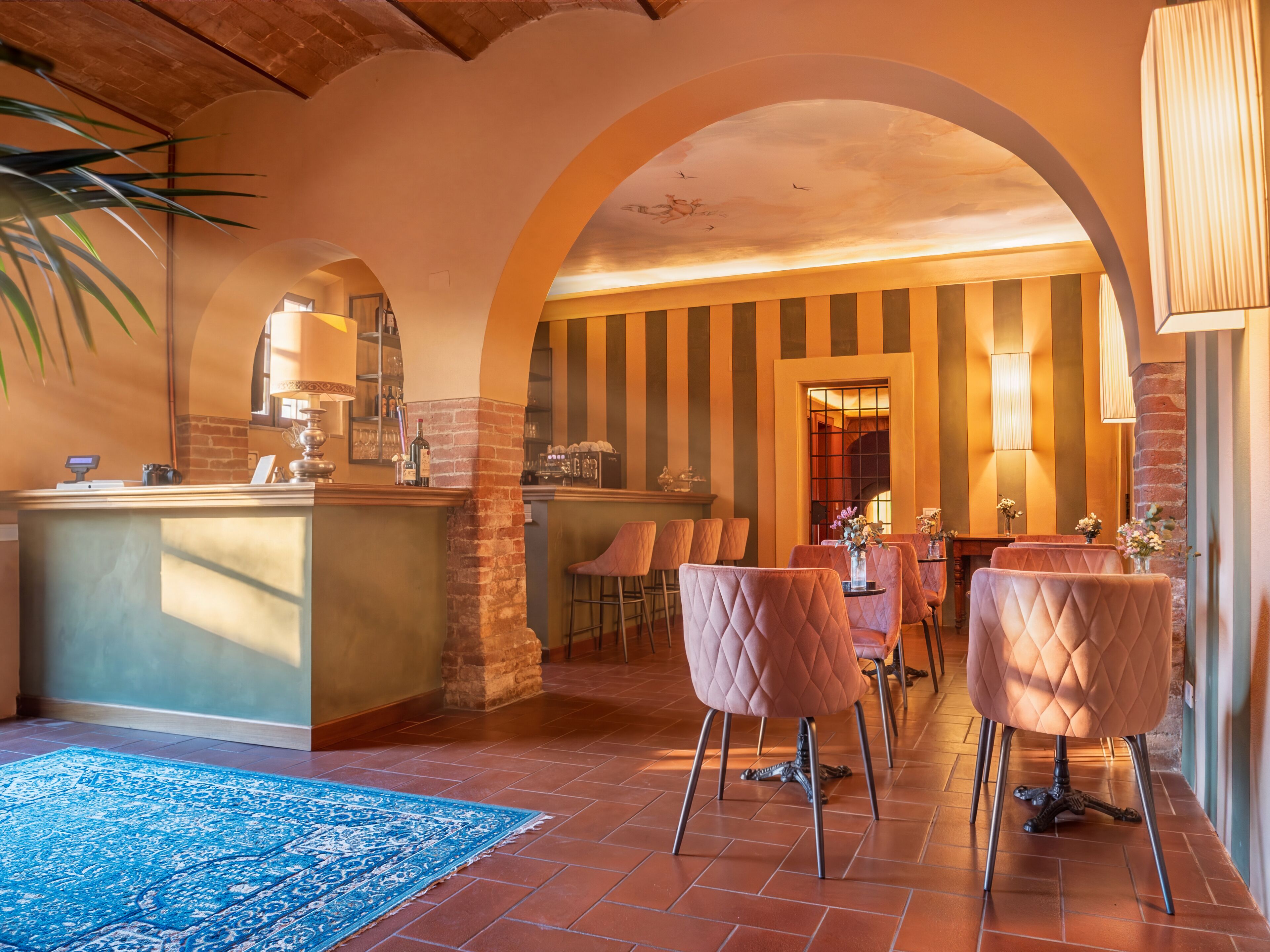A bar area with a counter, bar stools, and a blue rug.