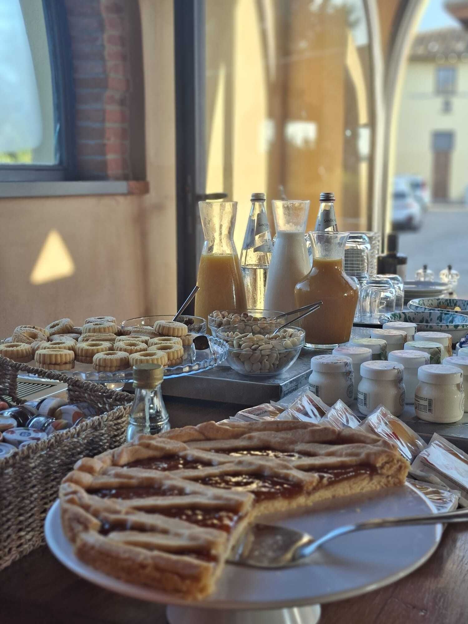 Un buffet de petit-déjeuner proposant divers pâtisseries, une tarte et des boissons.