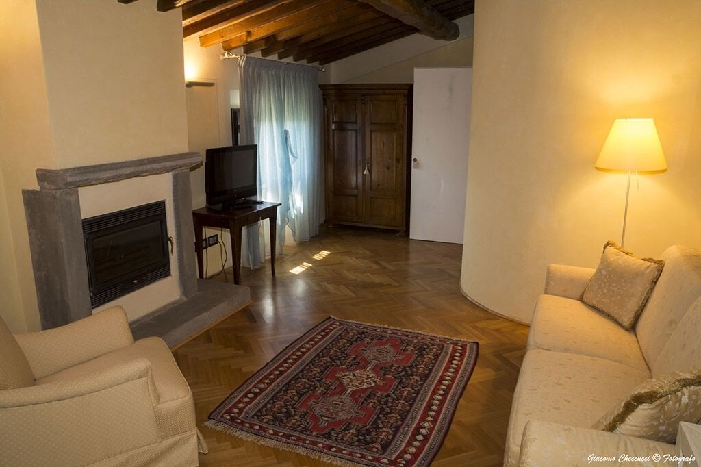 A living room with a fireplace, a television, a sofa, and a lamp.