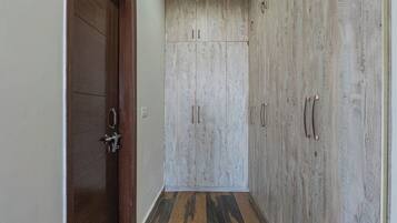 A hallway with wooden flooring and a wardrobe with multiple doors.