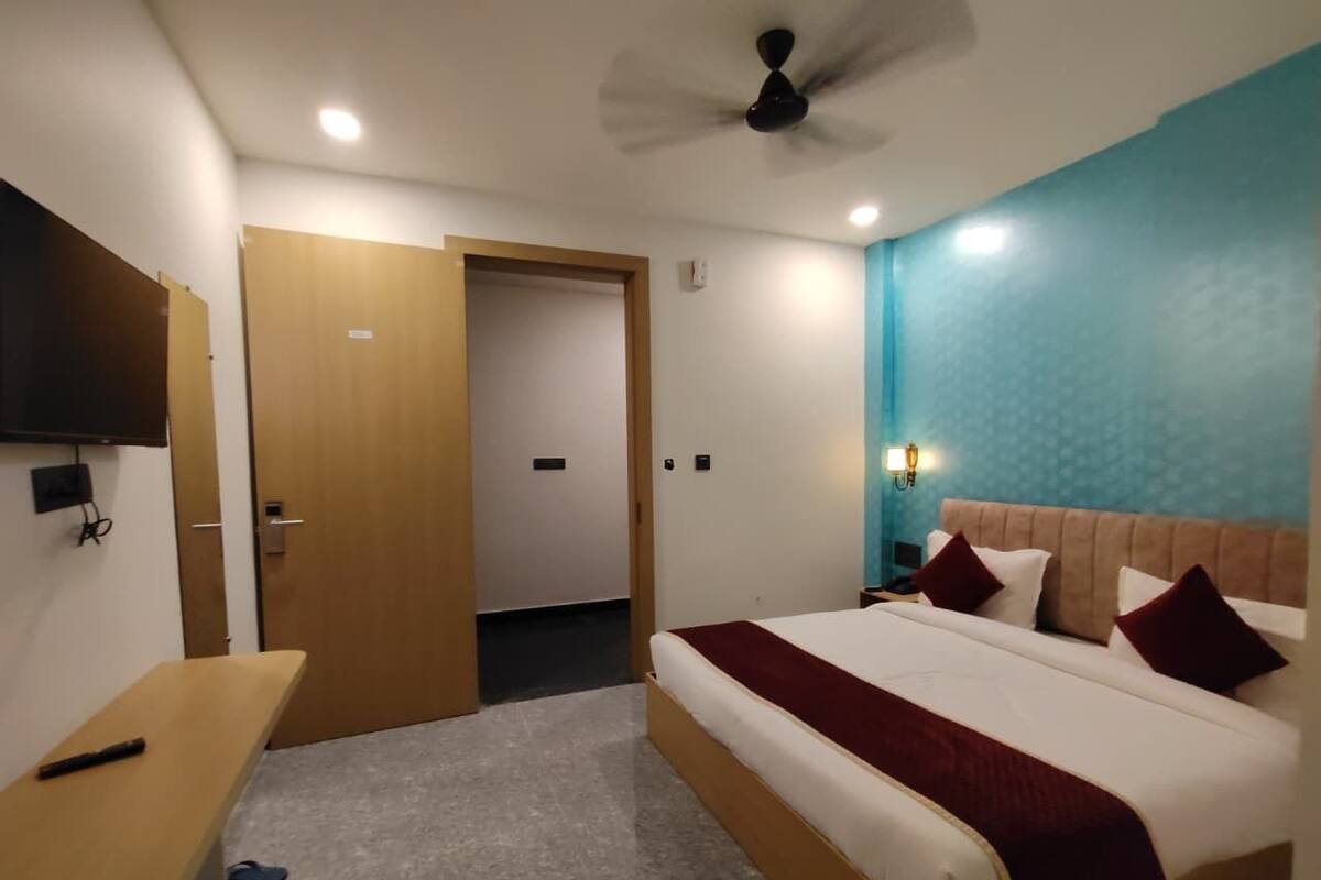 Une chambre d’hôtel avec un lit, une table de chevet et un bureau.