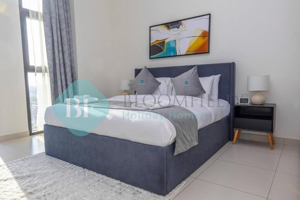 A modern bedroom with a large bed, a nightstand, and a wall-mounted abstract painting.