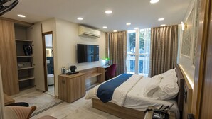 Ein Hotelzimmer mit Bett, Schreibtisch, Stuhl und Fernseher.