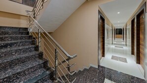 Ein modernes Hotelinnere mit einer Marmortreppe, einer langen Diele und einer Wand mit Holzverkleidung.