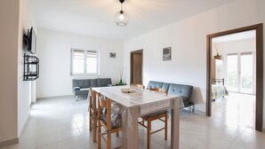 Un comedor amplio con una mesa grande, sillas e iluminación colgante moderna.