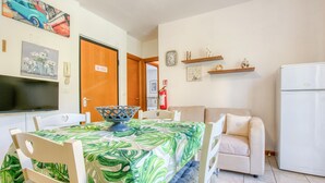 A dining area with a table set for four, a television, and a door with a 'No Smoking' sign. - Awesome apartment in Cogorno with WiFi (Cogorno)