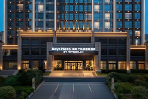 Una entrada de hotel moderna con un letrero que dice Days Plaza by Wyndham.