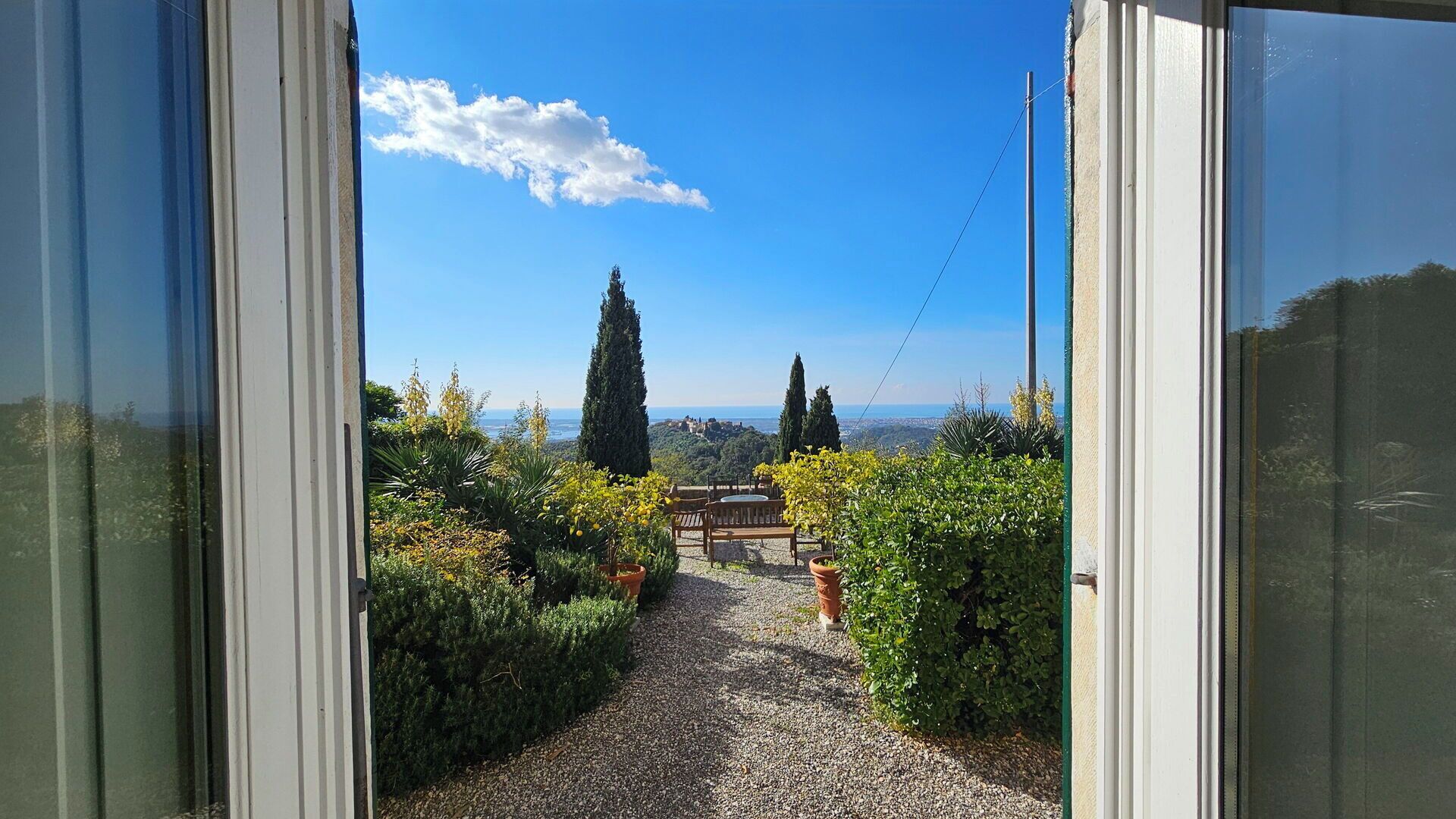 A pathway leading to a scenic view with a clear sky and distant buildings.