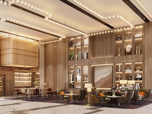 A modern hotel lobby with a seating area, a large chandelier, and a wall with shelves displaying various items.