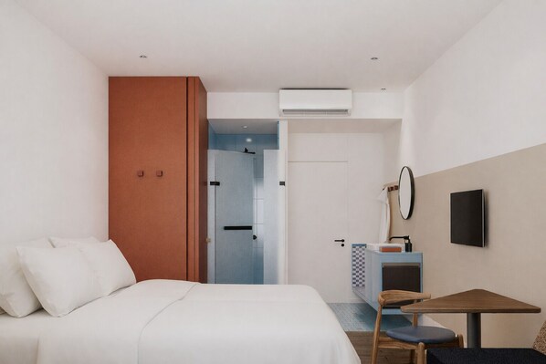 Une chambre d’hôtel équipée d’un lit, d’un bureau avec une chaise, d’une télévision et d’un appareil de climatisation.