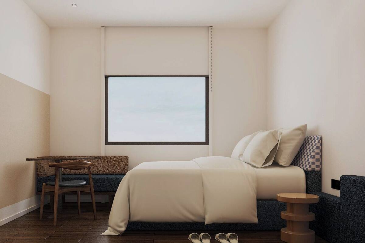 A small, modern bedroom with a bed, a desk, and a chair.