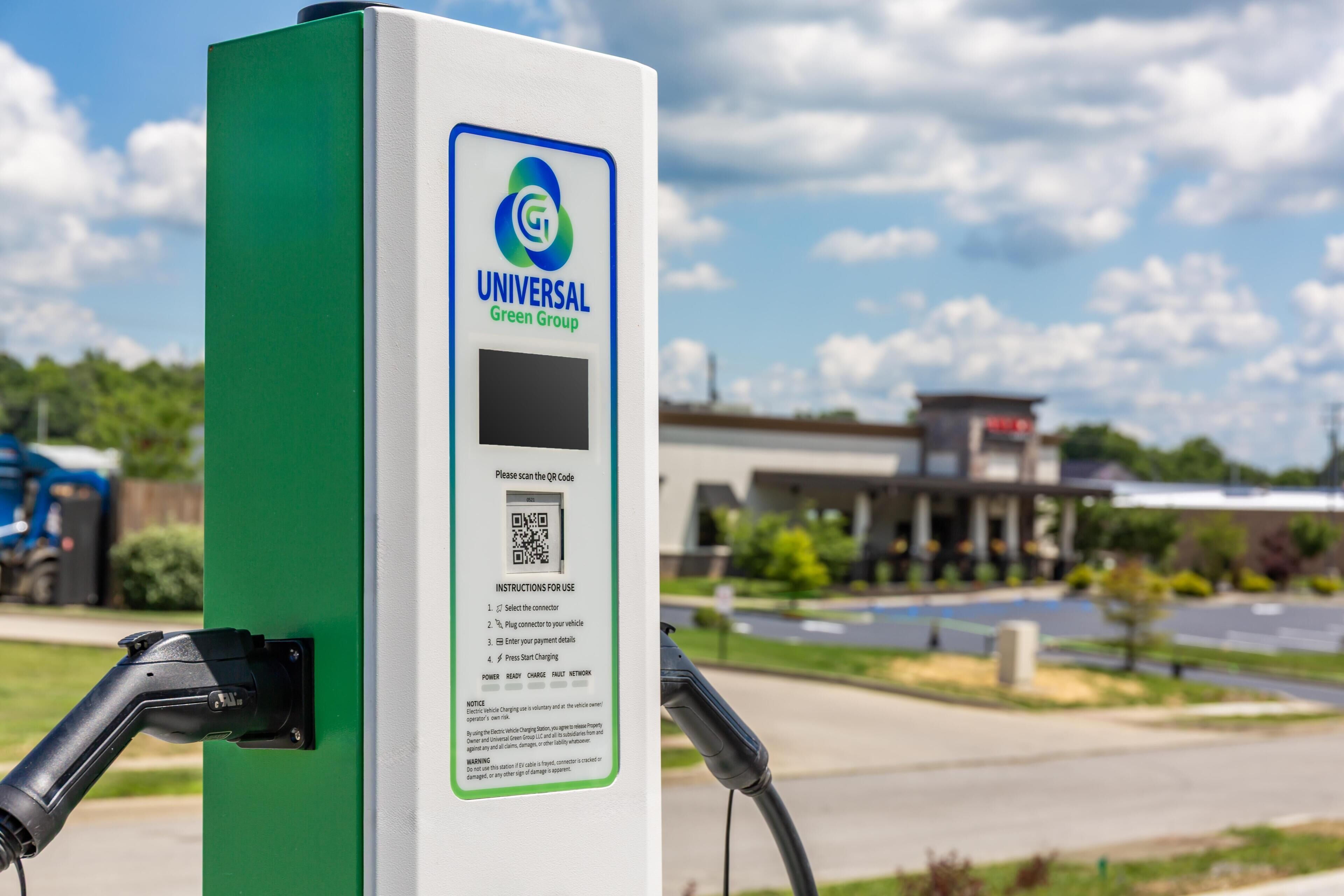 A charging station with a QR code, instructions, and a logo for Universal Green Group.
