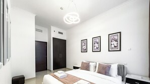 Una moderna camera d'hotel con un letto grande, un comodino, un armadio e tre quadri floreali appesi al muro.