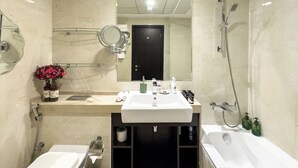 Un bagno moderno con uno specchio grande, un lavandino, un water, una vasca da bagno e una doccia.