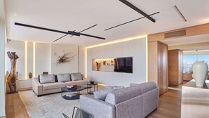 Ein modernes Wohnzimmer mit einer Couch, einem Couchtisch und einem an der Wand befestigten Flachbildfernseher.