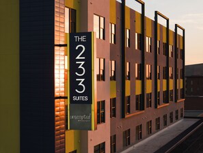 A hotel building with a sign indicating 'The 233 Suites' and 'Unscripted by Hyatt.' - The 233 Suites Unscripted by Hyatt (Mesa)