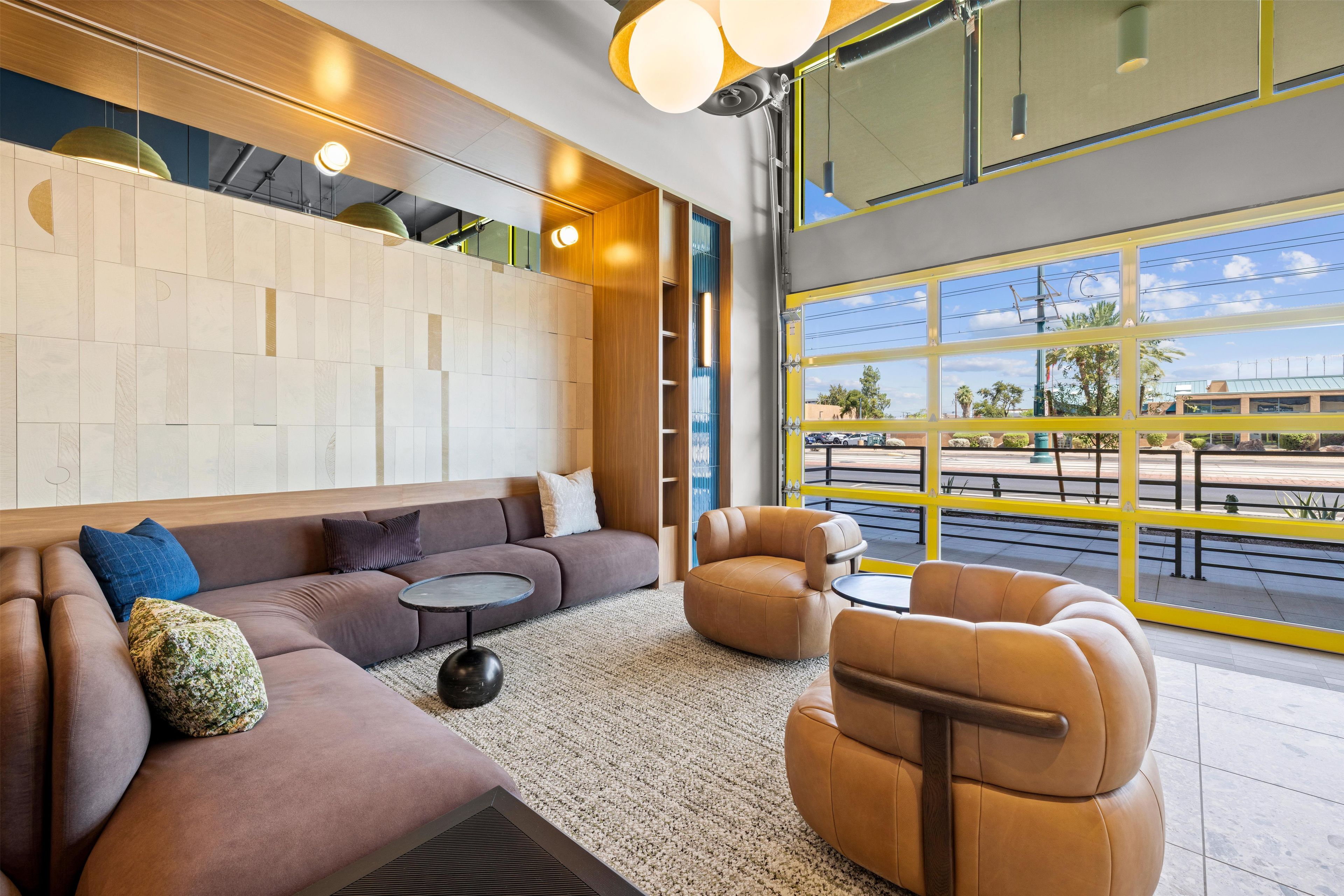 A modern lounge area with a sofa, armchairs, and a round table.