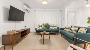 A living room with a TV, sofa, and coffee table. - Walkable Rincón Paradise near Plaza & Beaches w/ Carport (Rincon)