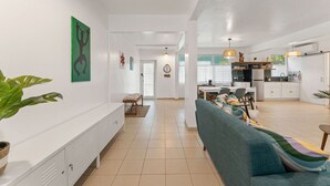 A spacious living area with a sofa, dining table, and kitchen in the background. - Walkable Rincón Paradise near Plaza & Beaches w/ Carport (Rincon)