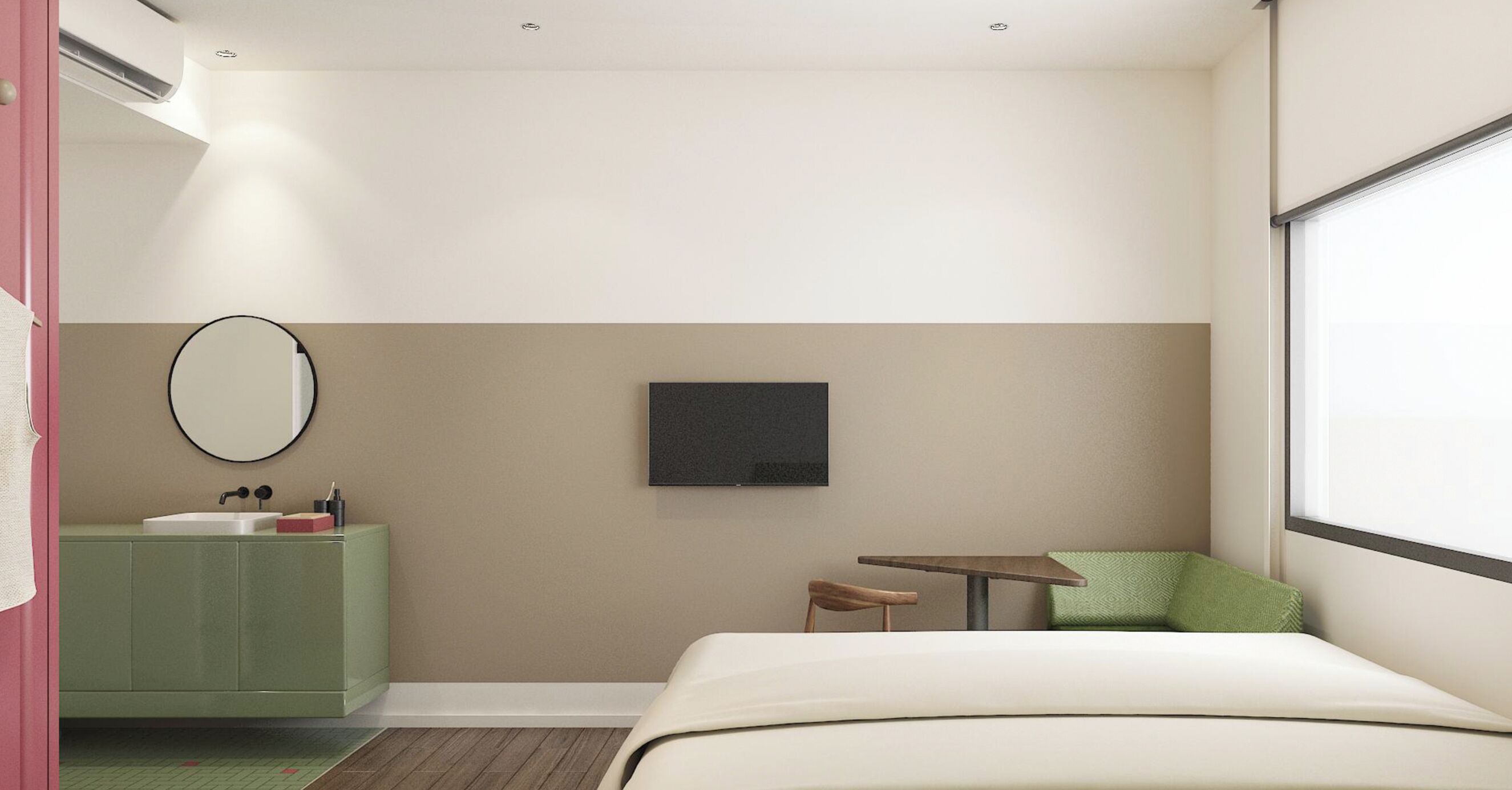 A hotel room with a bed, a small table, a chair, a green sofa, a mirror, and a TV.