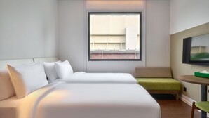 Een hotelkamer met een bed, een tafeltje, een stoel en een televisie.