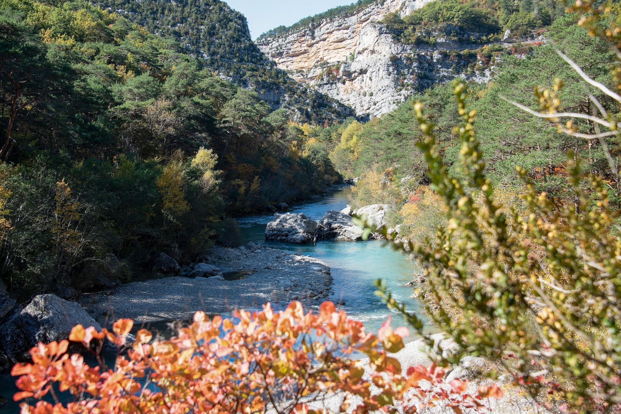 A river flowing through a mountainous area with rocky terrain and dense vegetation.