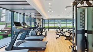 A modern gym with treadmills, weight machines, and dumbbells. - Canal View 1BR Near Business Bay Metro (Dubai)