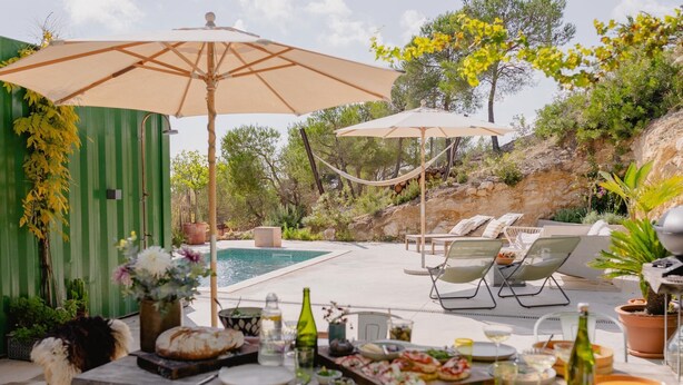 Un espace extérieur aménagé pour les repas, avec une piscine, des chaises longues et des parasols.