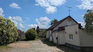 A residential building with a sloped roof, a visible antenna, and a gravel driveway. - A charming countryside accommodation near Malmö (Oxie)