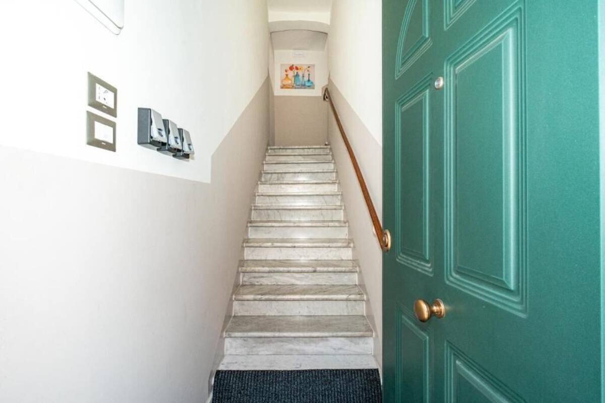 A marble staircase leading to a green door with a doorknob.