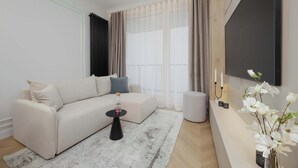 Ein modernes Wohnzimmer mit einem beigen Sofa, einem kleinen schwarzen Beistelltisch, einem weißen Teppich und einer weißen Vase mit Blumen.